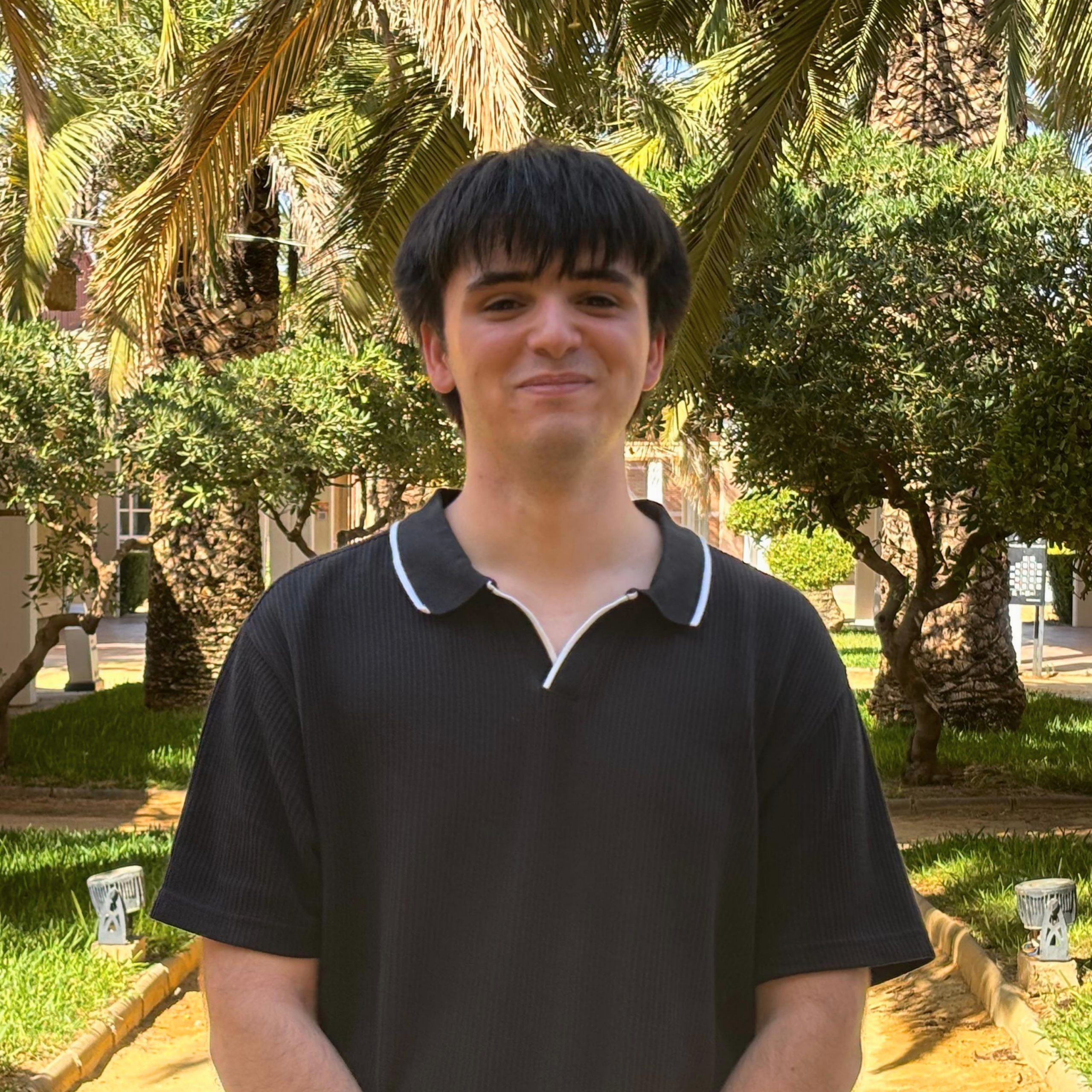 1 Foto de Andrés Campillo Ponce con fondo de palmeras y cesped.